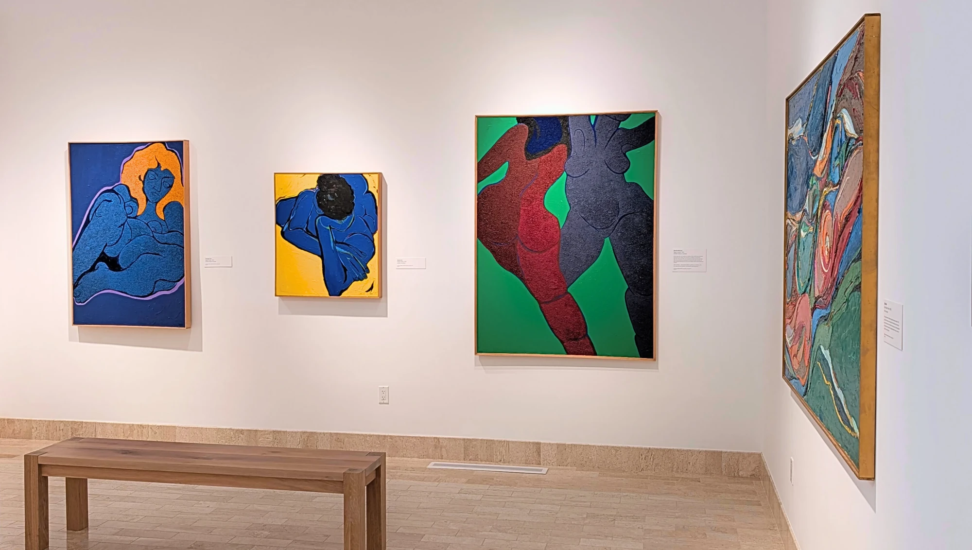 Four Rita Deanin Abbey Paintings hang on the wall. 3 are acrylic and mixed media relief paintings featuring female nudes. The three paintings are 'Orange Hair' (1974), 'Black Girl' (1972), and 'Dance Eternal' (1974). At an angle sits the 4th painting. It is an oil painting of another female nude titled 'Ophelia' (1962)