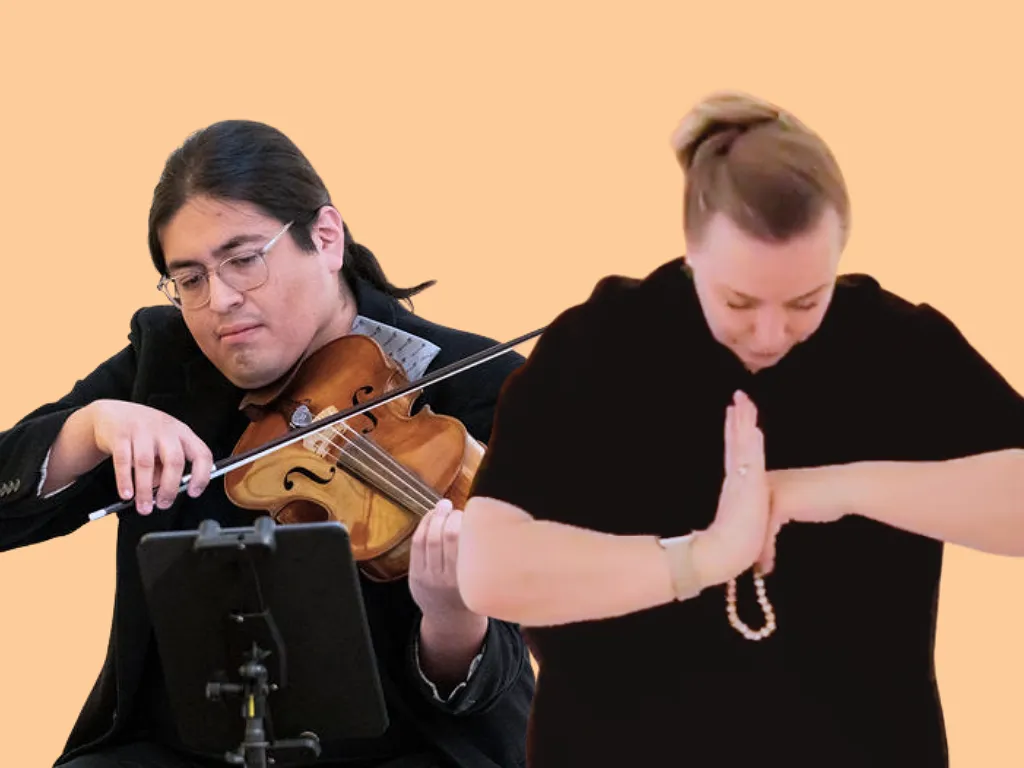 Two people wearing black, Arturo Hernandez Gomez playing a violin and Nicola Kilusyik in a meditative pose, in front of a solid light-orange backdrop